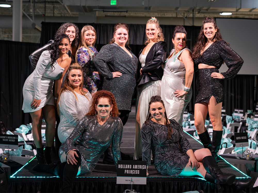 Group of woman in elegant dresses posing on a stage